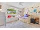 Charming bedroom featuring a window seat, cozy bed, and whimsical decor, creating a delightful space at 1837 Sweetwater West Cir, Apopka, FL 32712