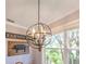 Dining room featuring a modern farmhouse chandelier and views of the outside greenery from the window at 1837 Sweetwater West Cir, Apopka, FL 32712