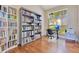 Bright home office with large bookshelves, a wooden desk, and backyard views at 1837 Sweetwater West Cir, Apopka, FL 32712