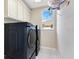 A modern laundry room equipped with side by side front load washer and dryer units at 1837 Sweetwater West Cir, Apopka, FL 32712