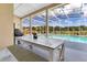 Covered patio with a dining area overlooking a screened pool and well-maintained backyard, offering a relaxing outdoor space at 1837 Sweetwater West Cir, Apopka, FL 32712