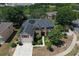 Aerial view of a two-story home featuring solar panels, a manicured lawn, and mature trees in a suburban neighborhood at 211 Hunt St, Clermont, FL 34711