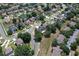 Aerial view showcasing the property nestled among other homes in a verdant neighborhood with tree lined streets at 211 Hunt St, Clermont, FL 34711