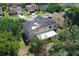 Aerial view of a two-story home featuring solar panels and a covered patio, surrounded by mature trees at 211 Hunt St, Clermont, FL 34711
