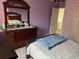 Comfortable bedroom features beautiful wood furniture, a patterned bedspread, and soft colors at 211 Hunt St, Clermont, FL 34711