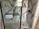 Modern shower boasts marble-look tile and black matte fixtures behind frameless glass enclosure at 211 Hunt St, Clermont, FL 34711