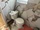 Well maintained bathroom features white toilet and marble-look tile from floor to ceiling at 211 Hunt St, Clermont, FL 34711