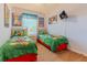A -friendly bedroom with two twin beds adorned with colorful bedding, and whimsical artwork at 2304 Silver Palm Dr # 304, Kissimmee, FL 34747