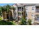 Elegant condominium building featuring balconies, lush landscaping, and a welcoming entrance at 2304 Silver Palm Dr # 304, Kissimmee, FL 34747