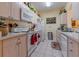 A bright kitchen features white appliances and countertops, paired with light wood cabinets and tile flooring at 2304 Silver Palm Dr # 304, Kissimmee, FL 34747