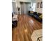 Spacious living room with hardwood floors, sleek black sofas, and bright natural light from large windows at 2882 Club Cortile Cir # B, Kissimmee, FL 34746