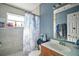 This bathroom features a shower/tub combo, light wood vanity, and blue accent wall at 2921 Bon Air Dr, Orlando, FL 32818