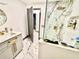 Bright bathroom featuring marble floors and walls, gray cabinets with gold hardware and glass shower at 2932 Larson St, Kissimmee, FL 34741