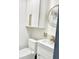 Stylish bathroom featuring white cabinetry, modern fixtures, and a sleek, round mirror at 2932 Larson St, Kissimmee, FL 34741