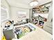 Bright bedroom featuring built in shelves filled with dinosaur toys and white wood-look floors at 2932 Larson St, Kissimmee, FL 34741