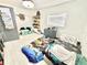Bright bedroom with white floors, and two beds with dinosaur themed bedding at 2932 Larson St, Kissimmee, FL 34741