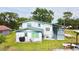 Two-story home with a backyard with a grill and seating area, surrounded by lush greenery and mature trees at 2932 Larson St, Kissimmee, FL 34741