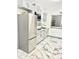 Modern kitchen featuring gray cabinets, stainless steel refrigerator, and sleek marble floors at 2932 Larson St, Kissimmee, FL 34741