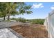 Landscaped backyard featuring a retaining wall and mulched area, providing a peaceful and private outdoor space at 2950 Inca Ave, Clermont, FL 34715