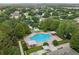 Aerial view of neighborhood community pool, landscaped with trees, umbrellas, and lounge seating at 2950 Inca Ave, Clermont, FL 34715