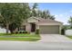 Charming single-story home with a well-manicured lawn, mature tree, and a two-car garage at 2950 Inca Ave, Clermont, FL 34715