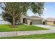 Well-kept single-story home features a lush green lawn and beautiful shade tree at 2950 Inca Ave, Clermont, FL 34715