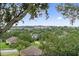 Overlook view of a neighborhood with lush green trees and a glimpse of a nearby lake at 2950 Inca Ave, Clermont, FL 34715