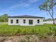 Back exterior of home with sliding glass door, windows, and green grass and yard space at 357 Marion Oaks Pass, Ocala, FL 34473
