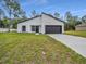 Contemporary home with dark trim and a well-maintained lawn and freshly poured driveway at 357 Marion Oaks Pass, Ocala, FL 34473