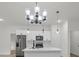 Modern white kitchen with stainless steel appliances and a stylish chandelier at 357 Marion Oaks Pass, Ocala, FL 34473