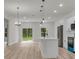 Modern kitchen with white cabinets, stainless steel appliances, and island with pendant lighting at 357 Marion Oaks Pass, Ocala, FL 34473