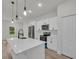 Well-lit kitchen featuring a kitchen island, stainless steel appliances, and sleek white cabinetry at 357 Marion Oaks Pass, Ocala, FL 34473