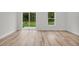 Bright and airy living area featuring wood-look floors and sliding glass doors to the backyard at 357 Marion Oaks Pass, Ocala, FL 34473