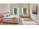 Serene main bedroom featuring two bright windows, stylish decor, and a comfortable, inviting ambiance at 357 Marion Oaks Pass, Ocala, FL 34473