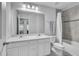 Well-lit bathroom includes a double sink vanity, large mirror, and a shower-tub combination with tile surround at 3961 Crawley Down Loop, Sanford, FL 32773