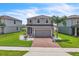Charming two-story home with a brick driveway, well-maintained lawn, and palm tree at 3961 Crawley Down Loop, Sanford, FL 32773