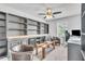 Bright living room featuring stylish built-in shelving, comfortable seating, and a ceiling fan with a light fixture at 3961 Crawley Down Loop, Sanford, FL 32773
