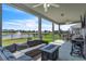 Relaxing covered patio with comfortable seating, outdoor kitchen, and picturesque views of the serene pond at 3961 Crawley Down Loop, Sanford, FL 32773