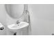 Simple powder room with modern pedestal sink, oval mirror and neutral decor, offering a minimalist and clean space at 3961 Crawley Down Loop, Sanford, FL 32773