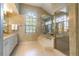 A bright bathroom features a soaking tub, glass enclosed shower, vanity and window at 4218 Inwood Landing Dr, Orlando, FL 32812