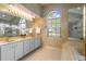 Bright bathroom with a double vanity, a soaking tub with window, and glass enclosed shower at 4218 Inwood Landing Dr, Orlando, FL 32812