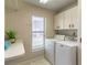 Laundry room with washer, dryer, folding counter and white cabinets at 4218 Inwood Landing Dr, Orlando, FL 32812