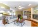 Cozy living room featuring a fireplace, white rug, and view to kitchen area for easy entertaining at 4218 Inwood Landing Dr, Orlando, FL 32812