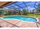 Inviting screened-in pool area features a brick patio and lush backyard views, perfect for relaxing and entertaining at 4218 Inwood Landing Dr, Orlando, FL 32812