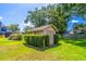 Backyard shed with a beautiful green hedge, lots of green grass, and blue skies at 4218 Inwood Landing Dr, Orlando, FL 32812