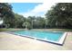 Community swimming pool with clear blue water and a fenced perimeter surrounded by mature trees at 474 Windmeadows St # 0, Altamonte Springs, FL 32701