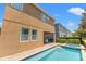 Exterior view of the backyard featuring a pool, spa, covered patio, and neighboring homes at 480 Lasso Dr, Kissimmee, FL 34747