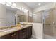 This full bathroom features double sinks with granite countertops and a glass walk-in shower at 480 Lasso Dr, Kissimmee, FL 34747