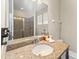 Bathroom vanity features granite counters, large mirror, tiled shower and neutral walls at 480 Lasso Dr, Kissimmee, FL 34747