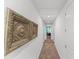 Hallway with decorative wall art, neutral walls, soft carpet and access to bedrooms at 480 Lasso Dr, Kissimmee, FL 34747